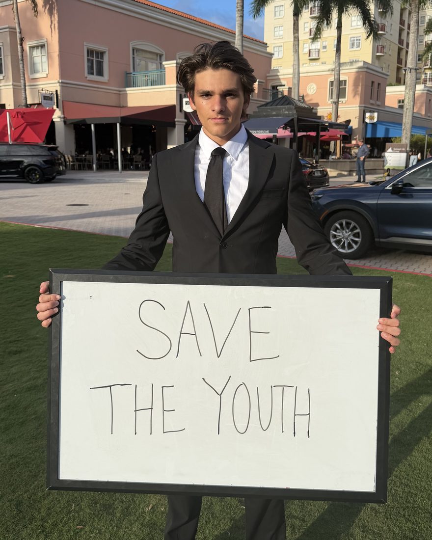 Liam Gimig holding a Save The Youth sign